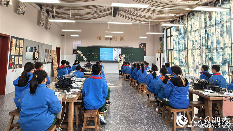 素质教育学校教室内,学生们正烙画团扇制作。人民网记者 吴茜薇摄