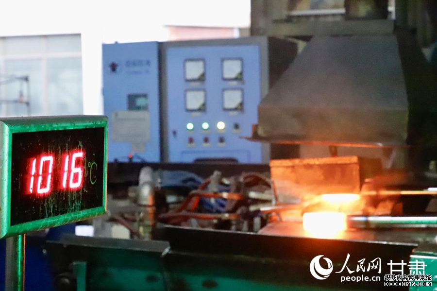 定西高强度紧固件股份有限公司智能化车床上,螺柱正经历千度高温的一体成型锻造。人民网记者 焦隆摄