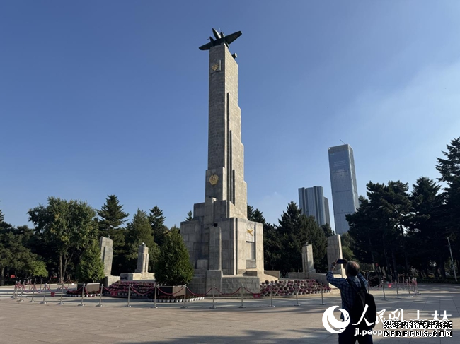用镜头记录苏联红军烈士纪念塔的侯志国。人民网记者 李思玥摄