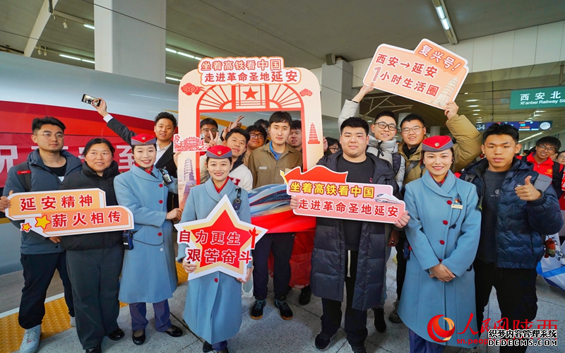 12月26日,旅客同铁路工作人员一起在候车室“打卡”。人民网记者 邓楠摄