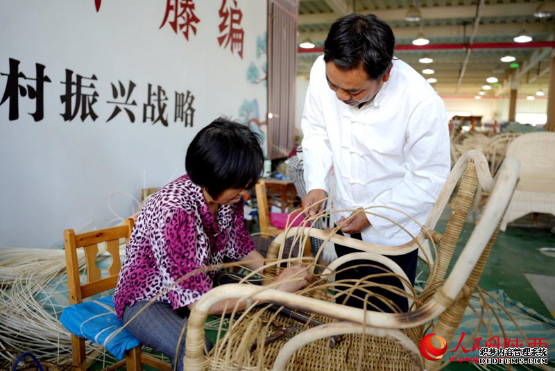 陈良顺(右)正在教授工人藤编技艺。人民网记者 邹星摄
